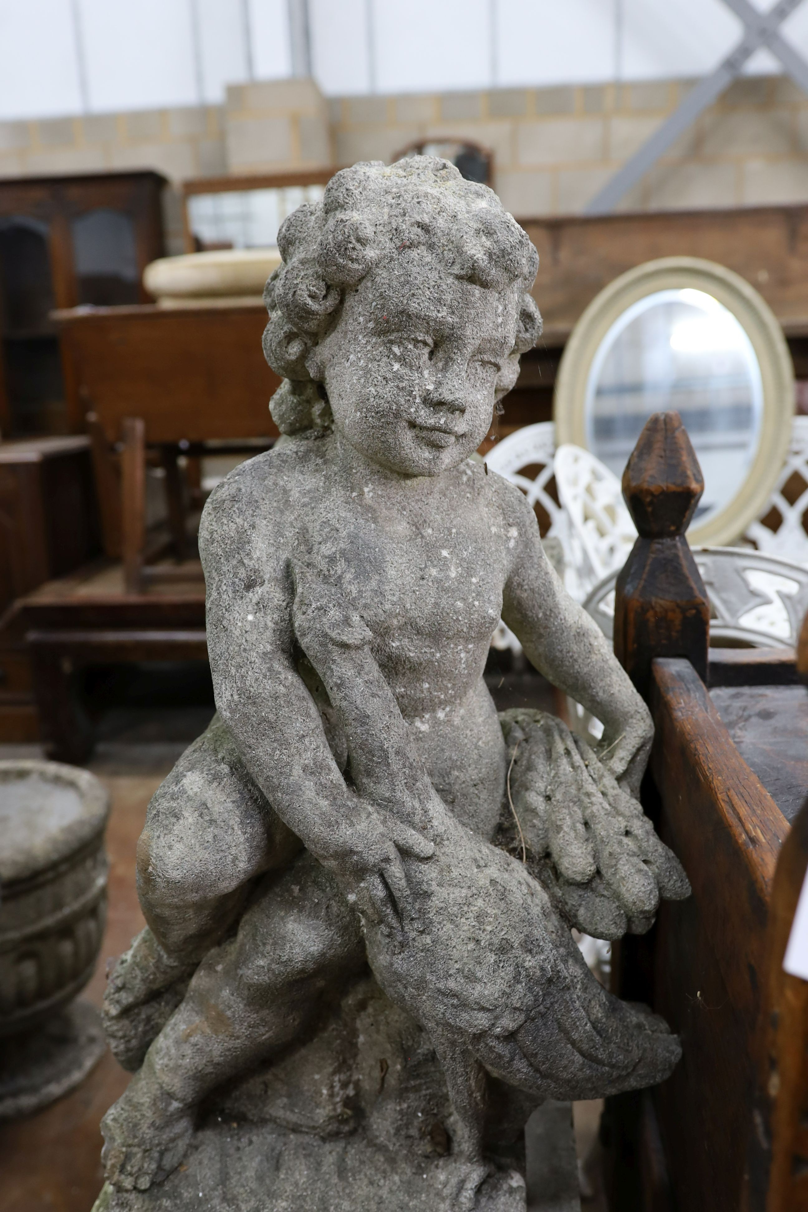 A pair of reconstituted stone cherub and dove garden ornaments on faux marble plinths, height 116cm